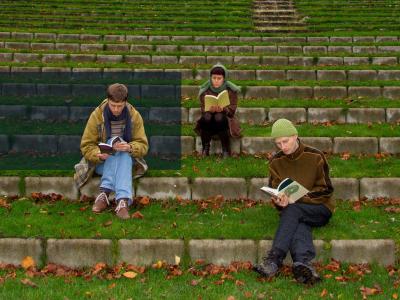 Tre unge fra Den grønne ungdomsbevægelse læser udendørs